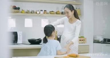 孕妇和她的女儿在家里做饭跳舞。家庭、食品、家庭和人的概念.
